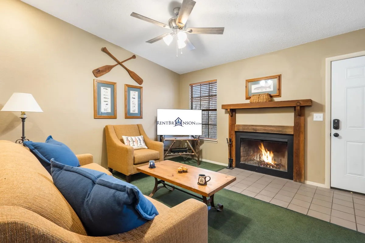 The image showcases a cozy living room with a warm fireplace, inviting sofa, coffee table, and charming decorative paddles, creating a nostalgic and welcoming atmosphere perfect for families or friends to gather and unwind.
